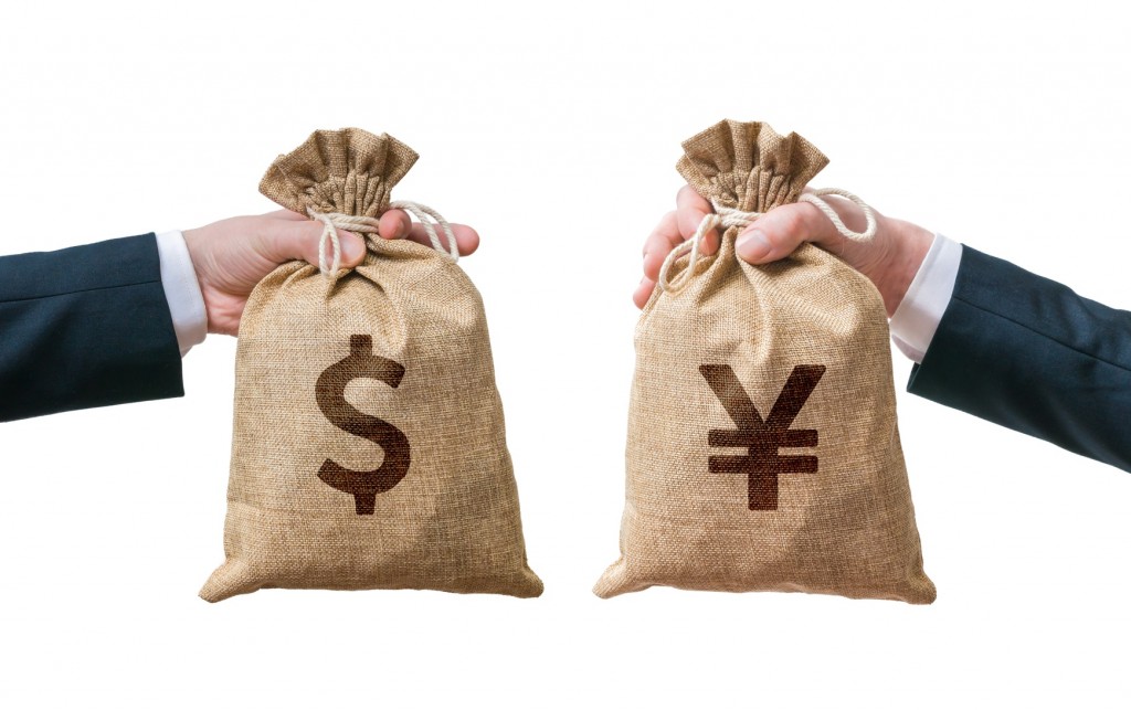 Exchange currency concept. Hands hold bag full of money - Dollar and Yen. Isolated on white background.